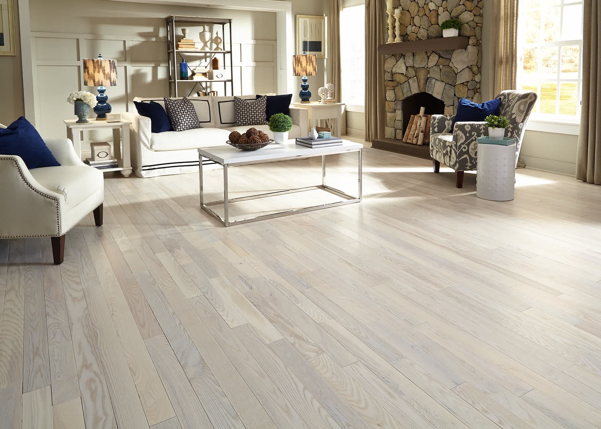 white and beige hardwood floor in living room with white sofa and navy blue accents