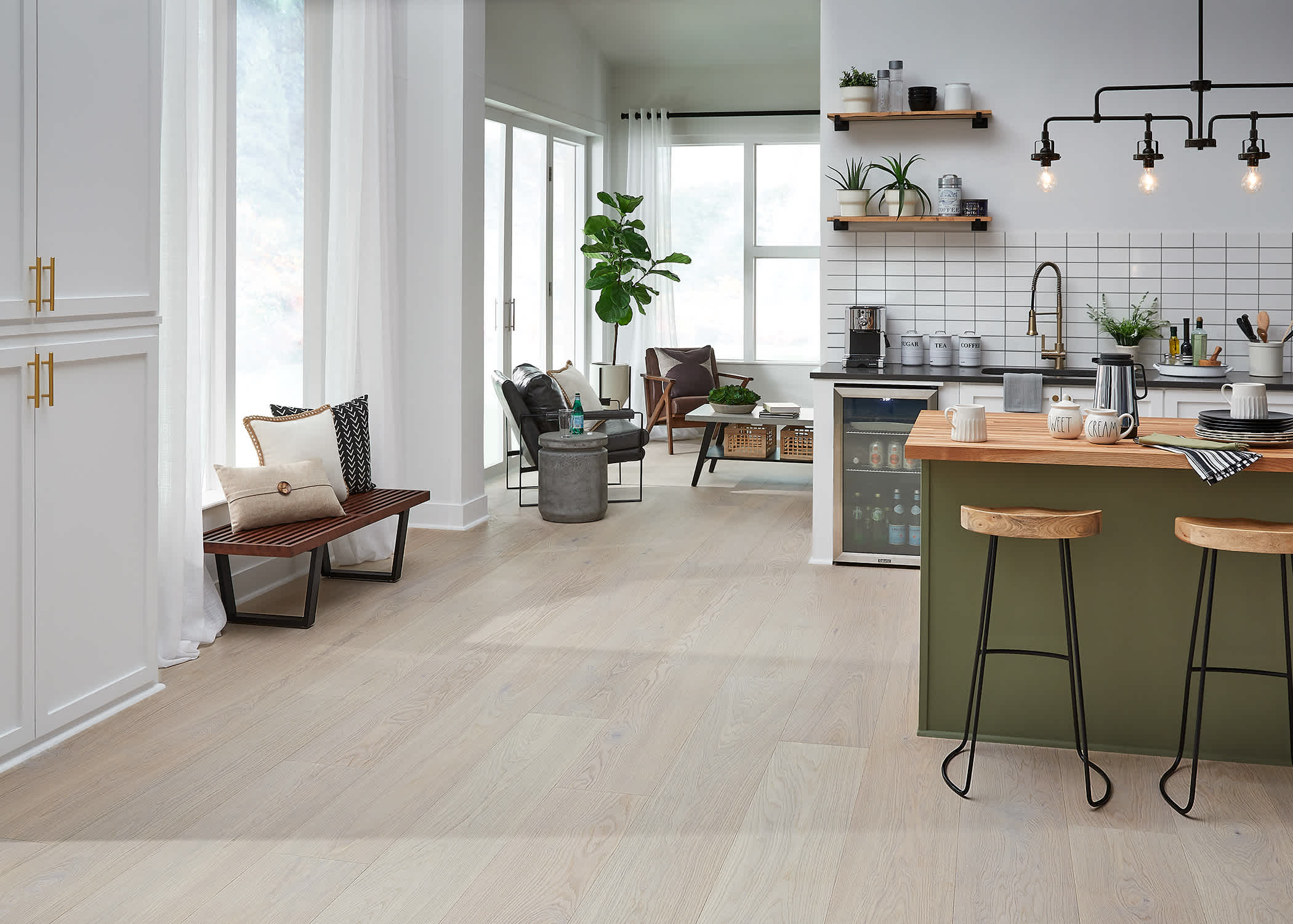 light brown water resistant hardwood floor in kitchen with green island and light wood stools plus subway tile b