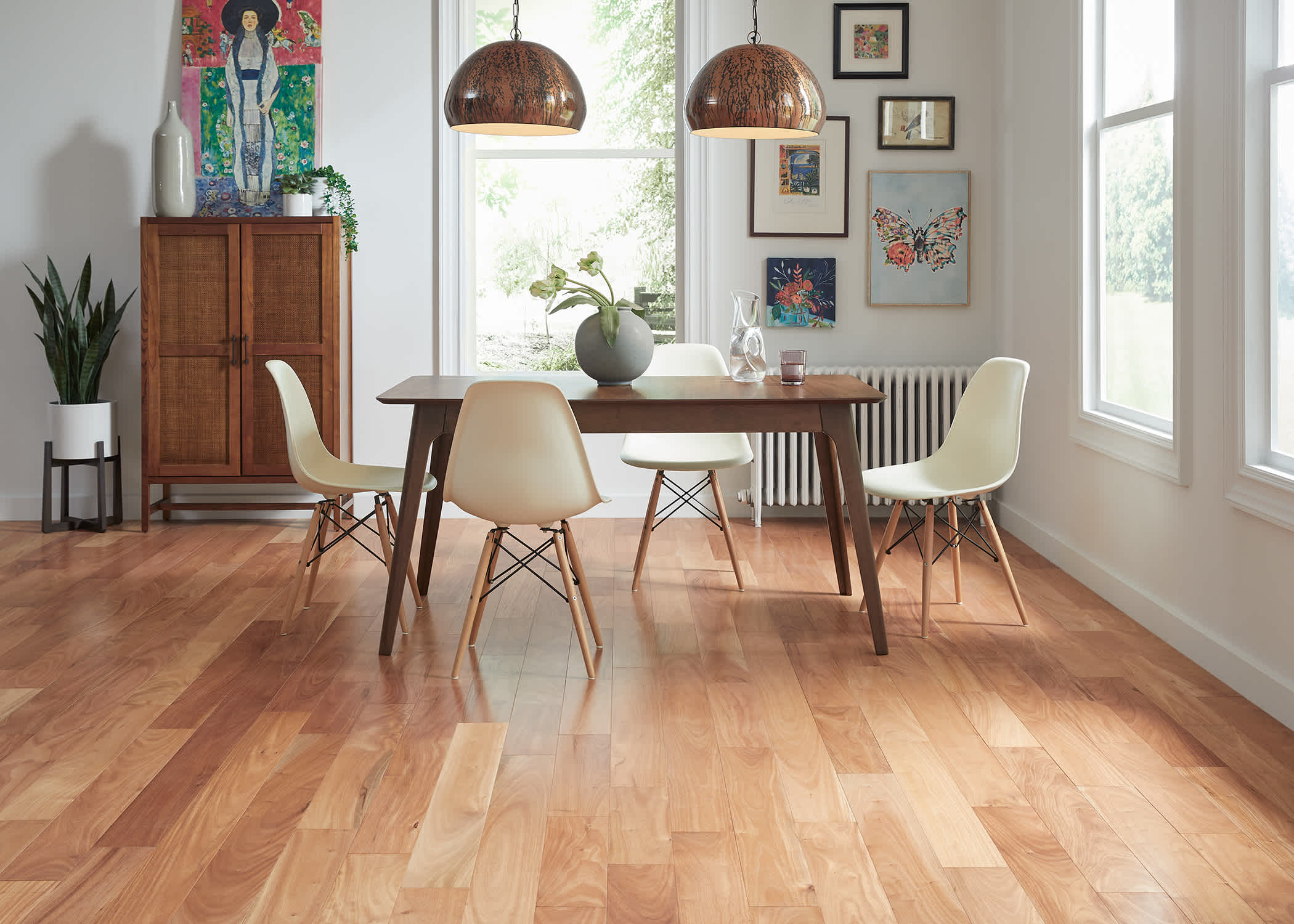 Brioche Distressed Engineered Hardwood Flooring in dining room with dark wood dining table plus white dining chairs plus wood pendant lighting and dark wood and rattan storage cabinet