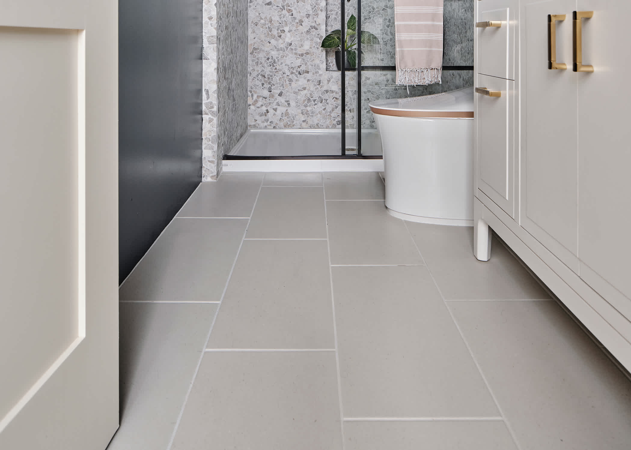 cream porcelain tile in main bathroom of 2023 HGTV Smart Home with off white vanity and gray and white mosaic tile