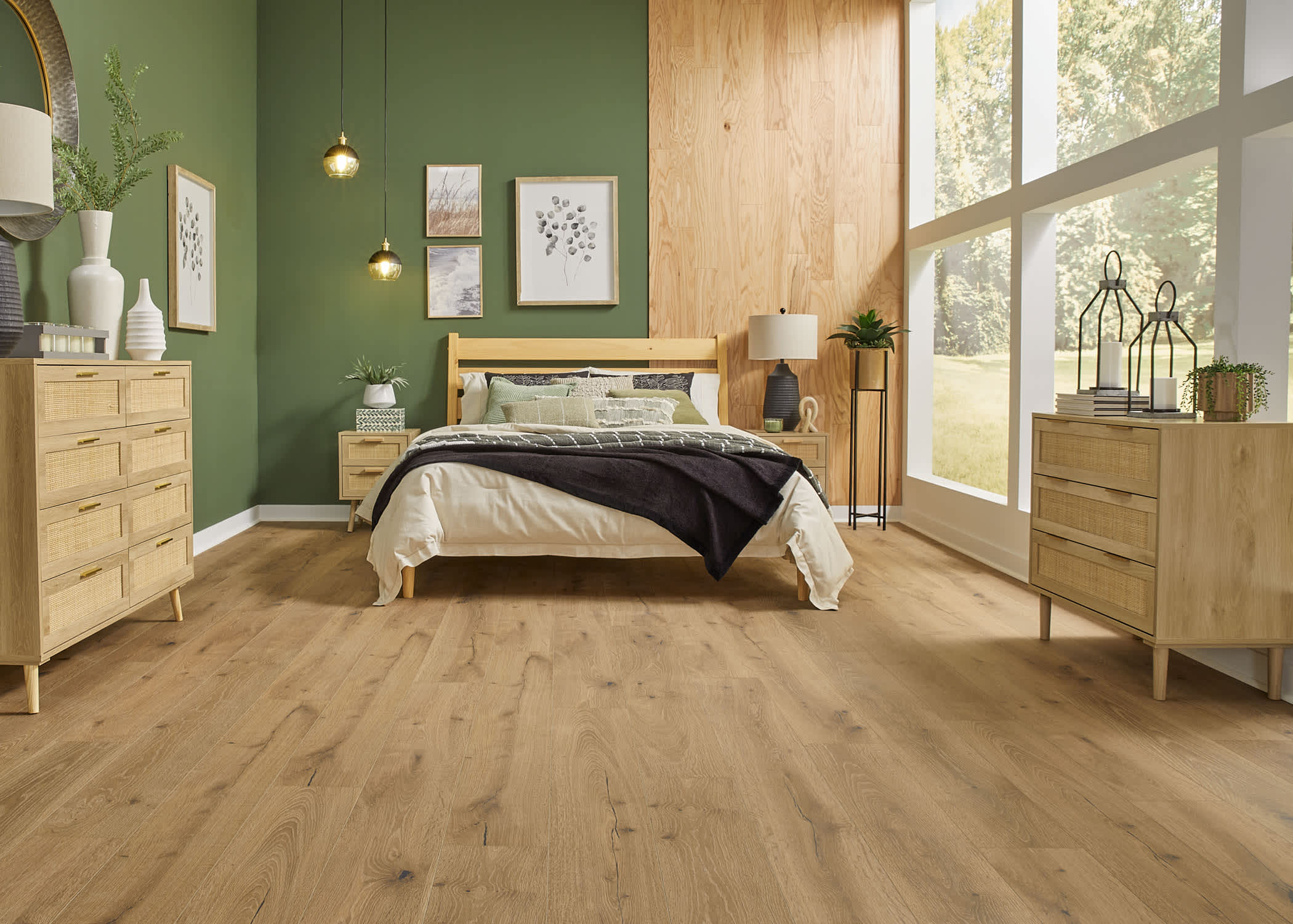 Blonde waterproof vinyl plank floor in bedroom with green walls plus blonde wood accent wall and blonde wood bed with cream and brown bedding and blonde wood tables