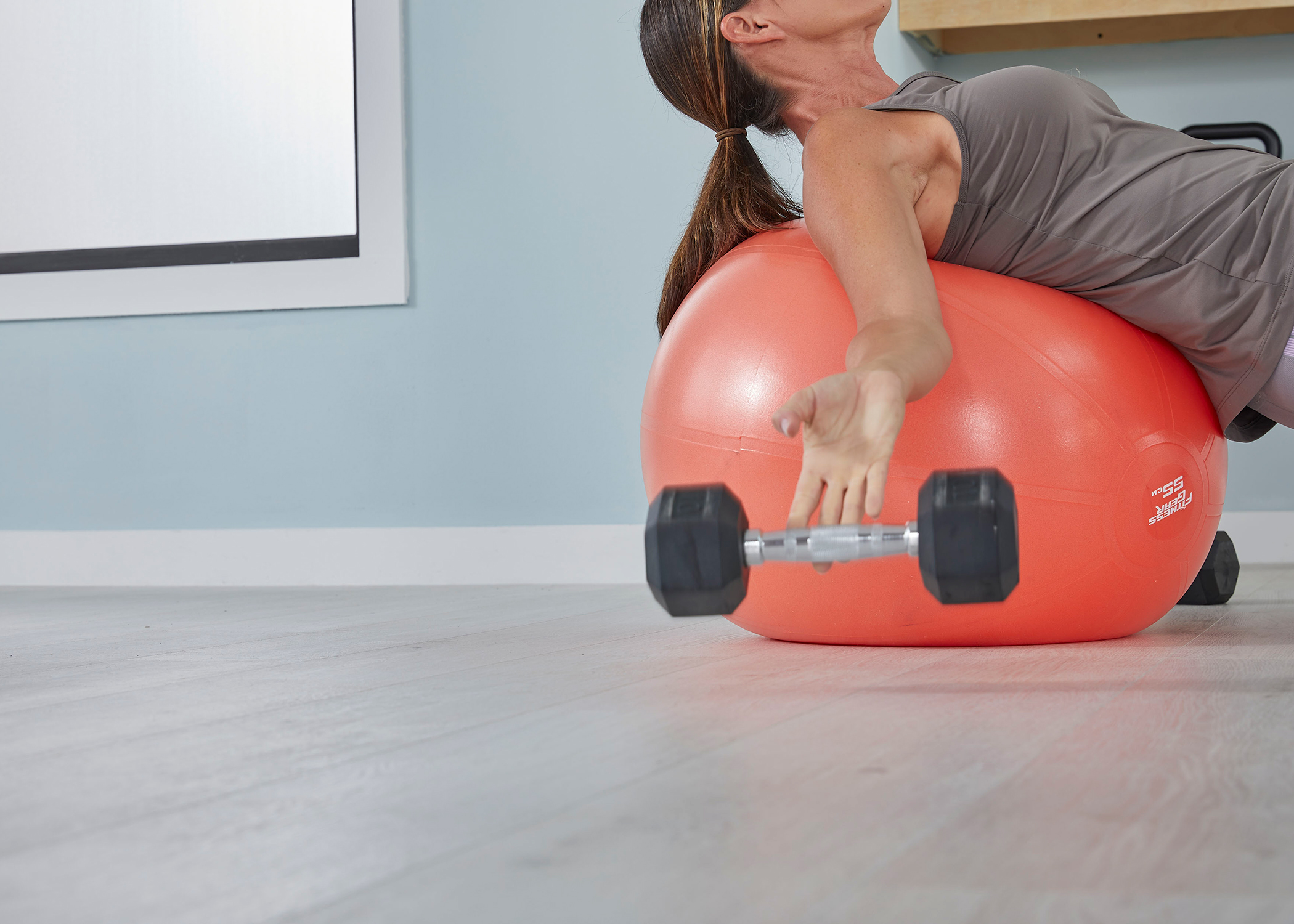 woman exercises with weights on waterproof hybrid wood flooring