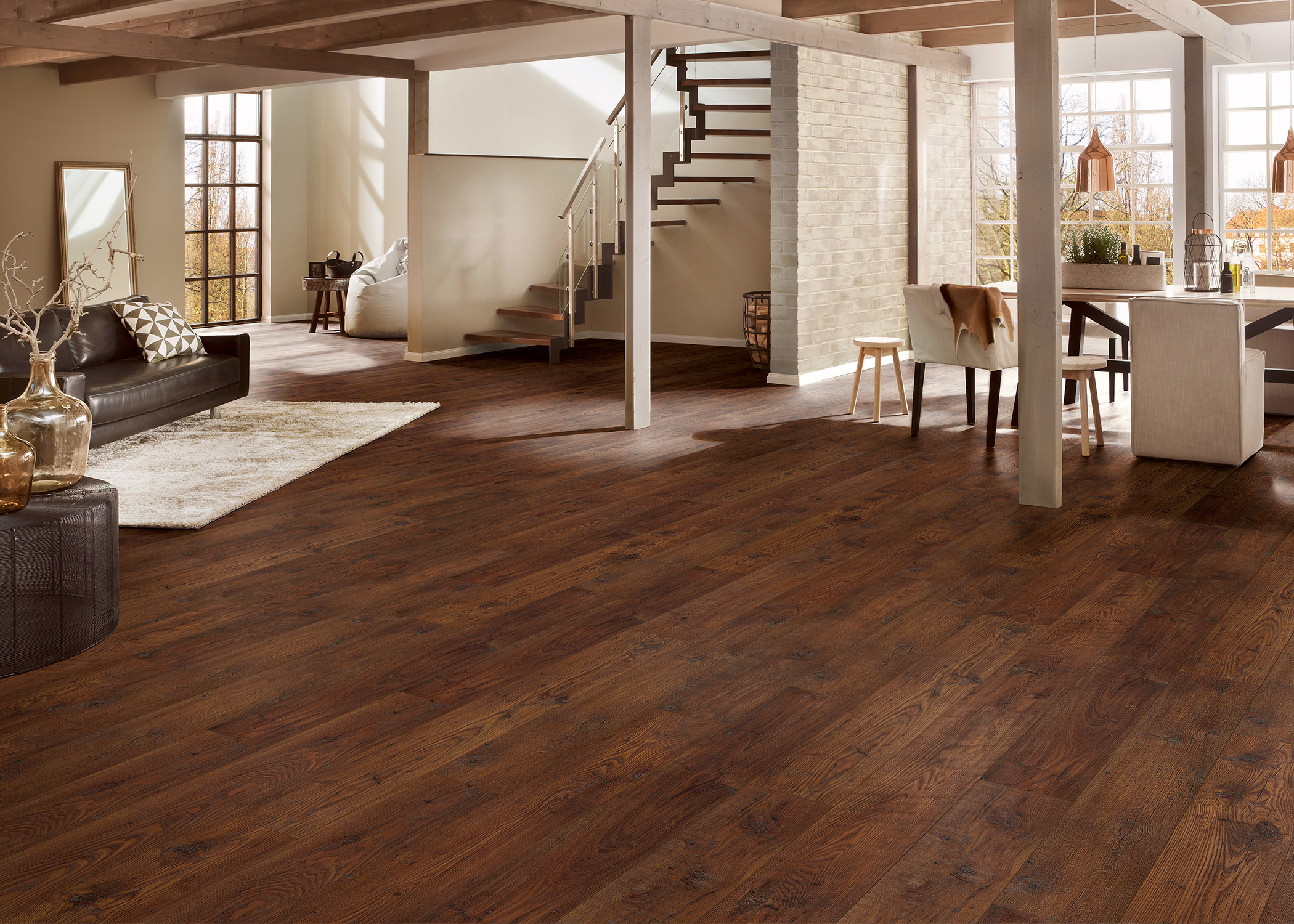 a large open living room with dark brown laminate flooring