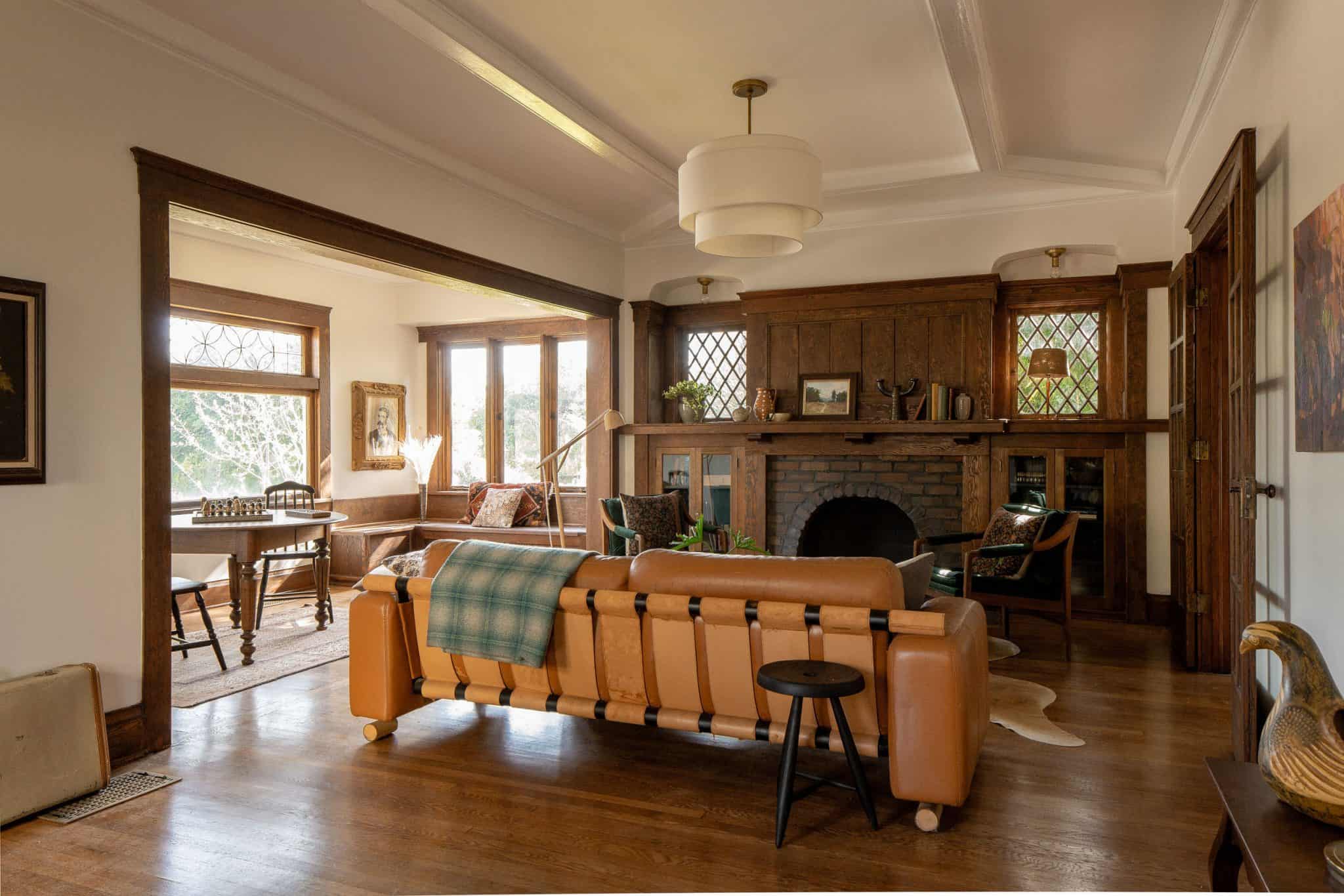 Living room with orange couch in craftsman home with exposed wood beams