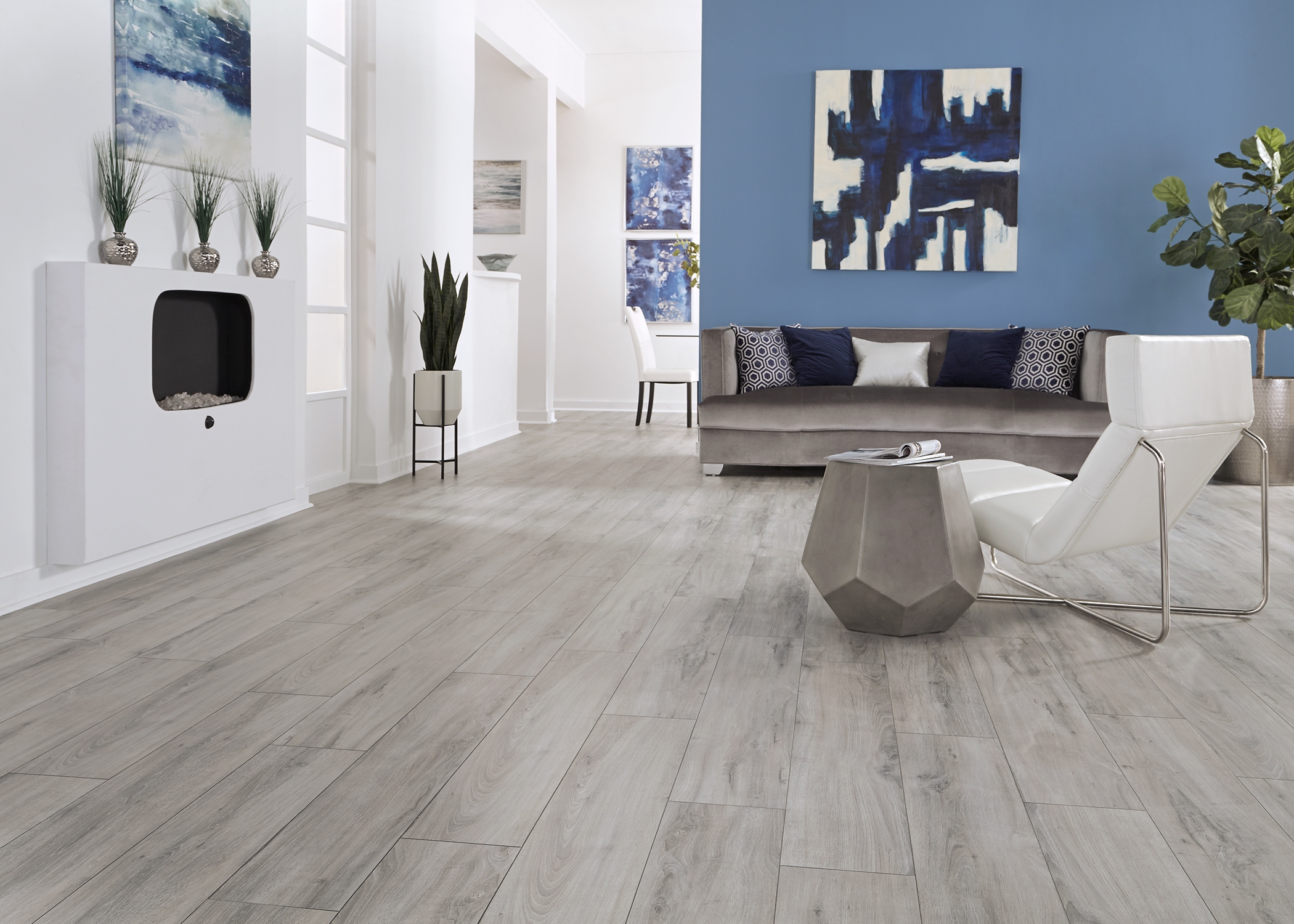 gray waterproof laminate floor in living room with gray velvet sofa plus white leather chair with metal base and blue walls