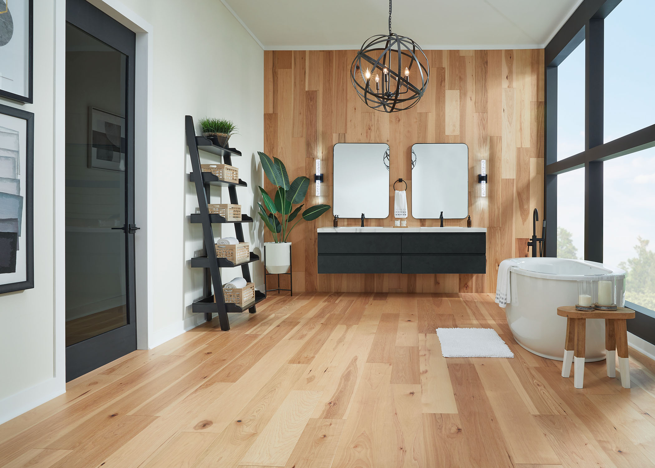 blonde water resistant engineered hardwood floor in bathroom with black floating dual vanity with black orb chandelier plus freestanding bathtub and floor to ceiling window