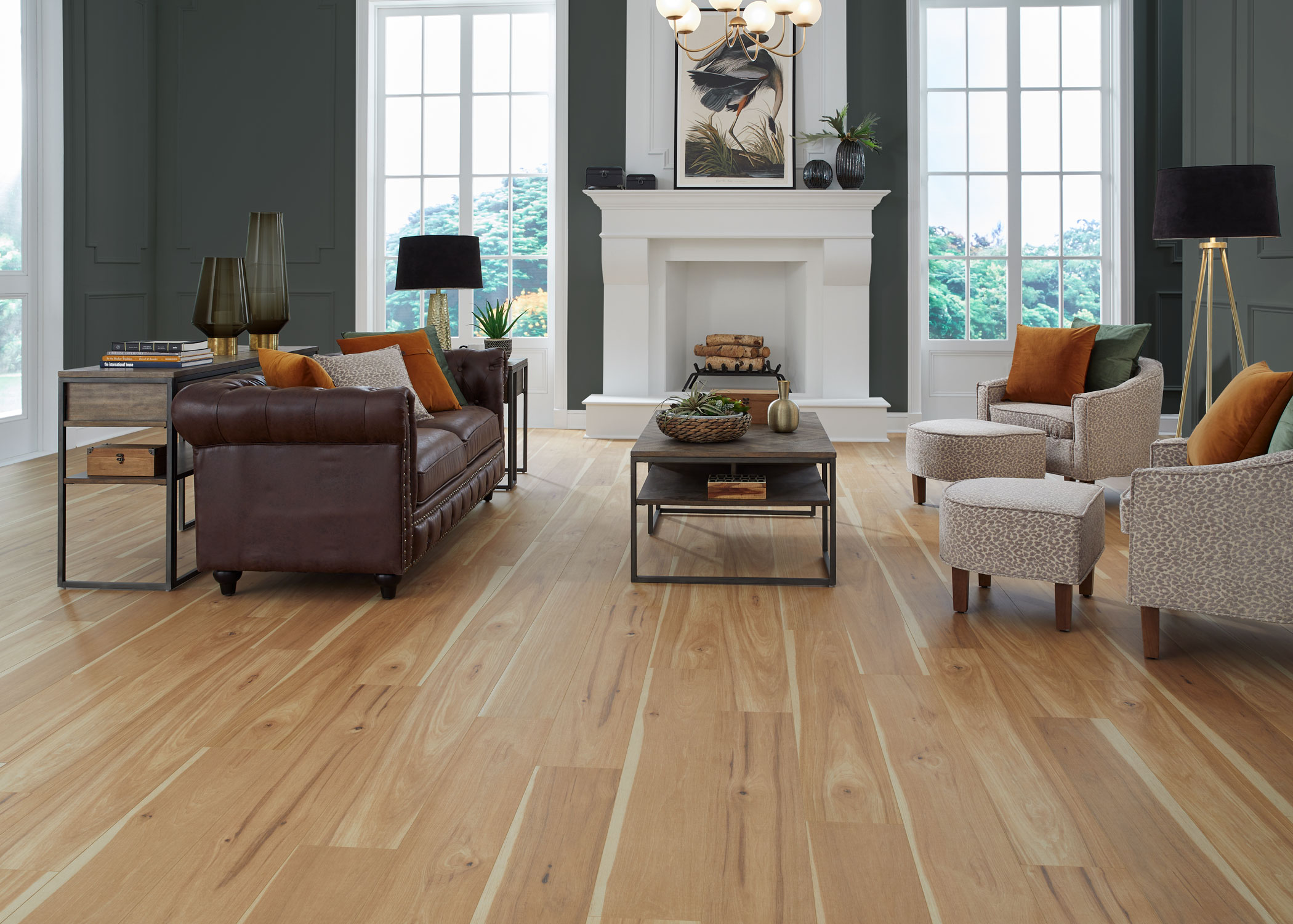 multi tone blonde waterproof hybrid resilient flooring in living room with dark brown leather sofa with animal print accent chairs and dark green walls