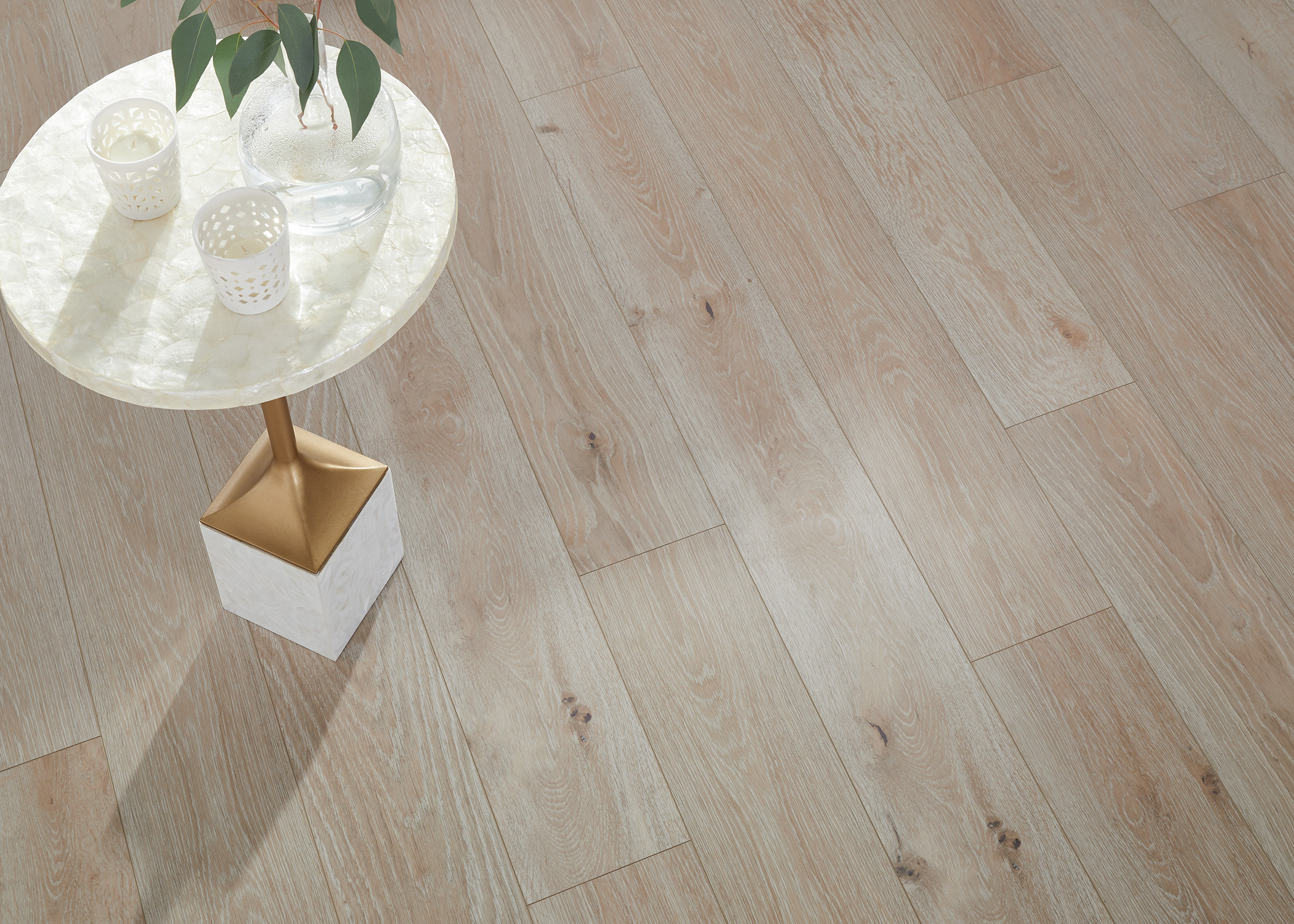 blonde with dark knots waterproof rigid vinyl plank  close up of floor with white and gold accent table