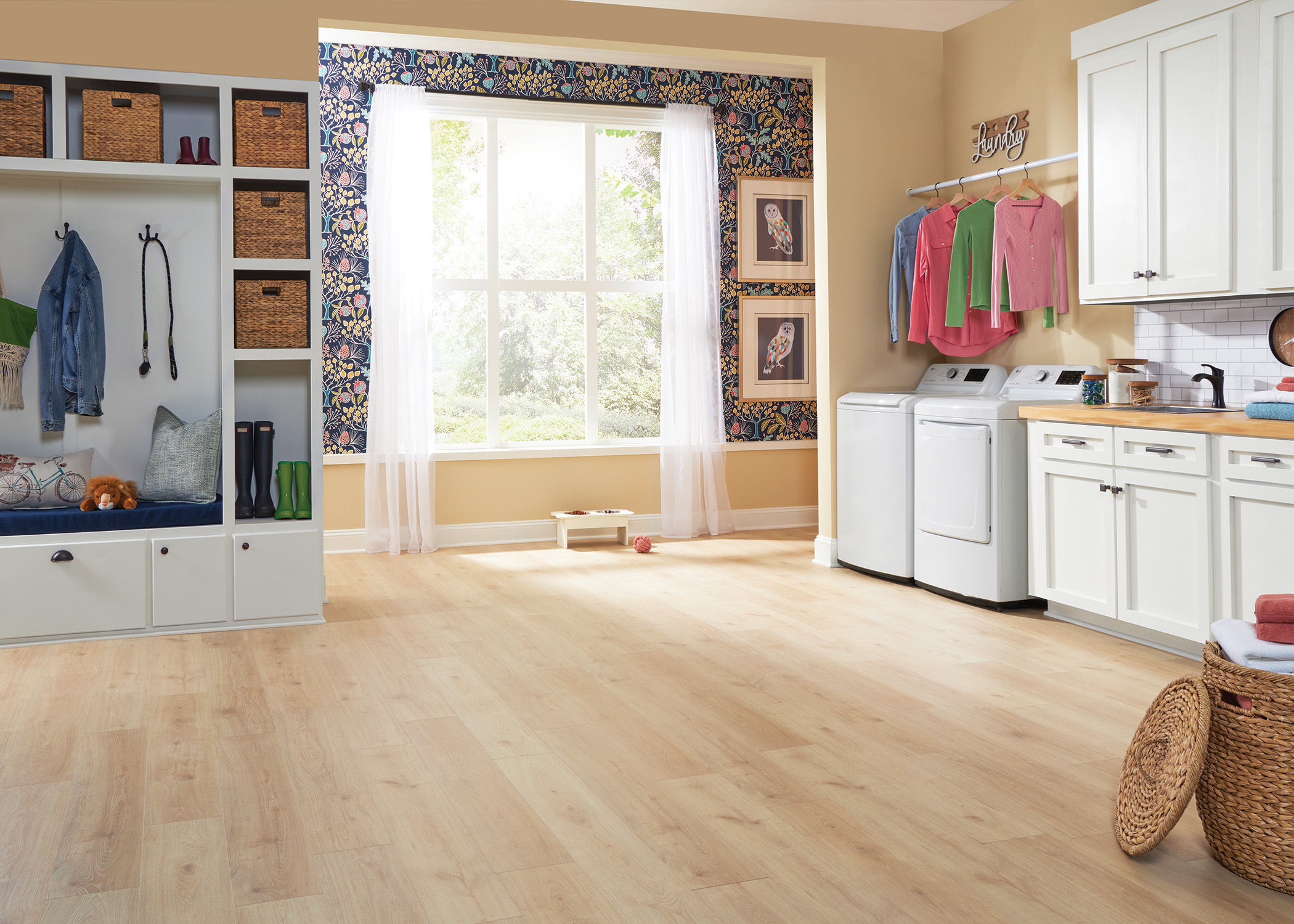 blonde waterproof hybrid resilient flooring in laundry room with white built in storage