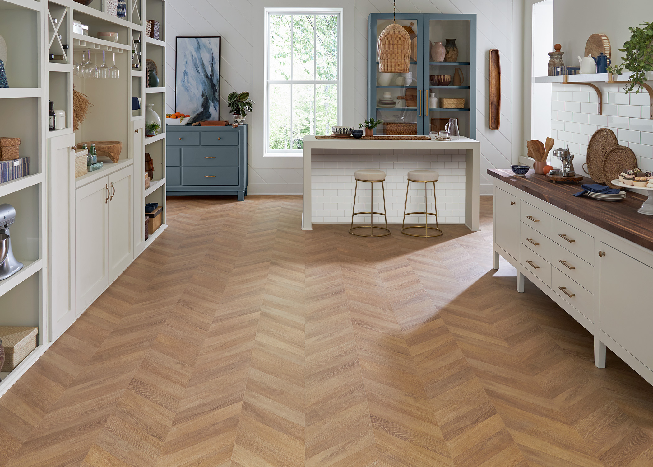 blonde chevron waterproof laminate floor in butler's pantry with butcher block counters plus blue cabinets and island with subway tile