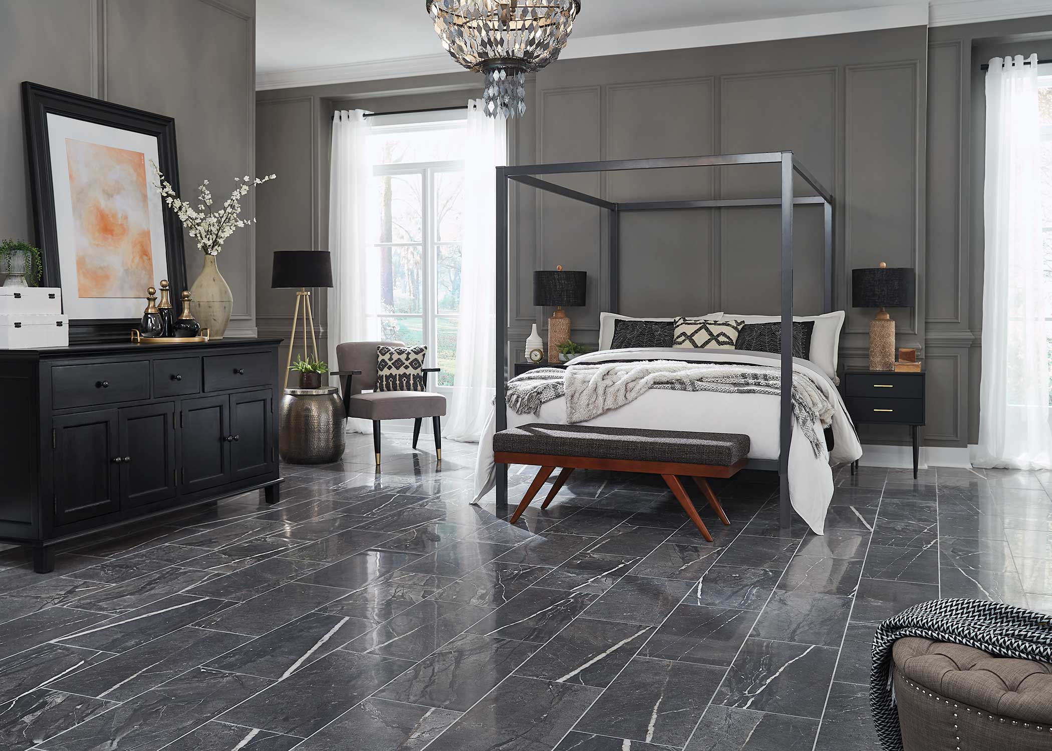 black and white marble look porcelain tile flooring in bedroom with black four poster bed plus gray walls and black side tables with black and brown matching table lamps