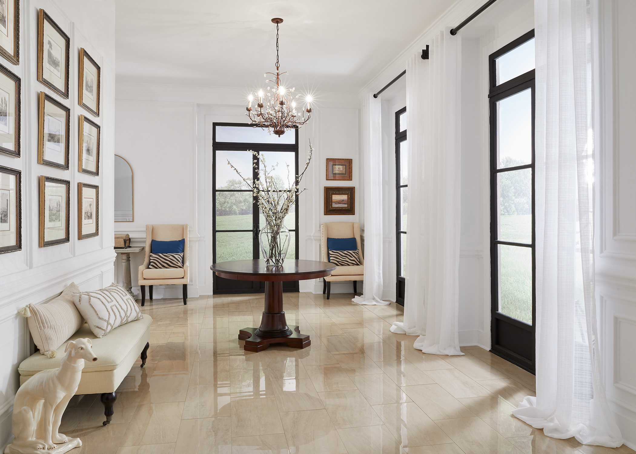 cream polished porcelain tile flooring in entryway with white sheer curtains, dark brown console table and cream accent chairs