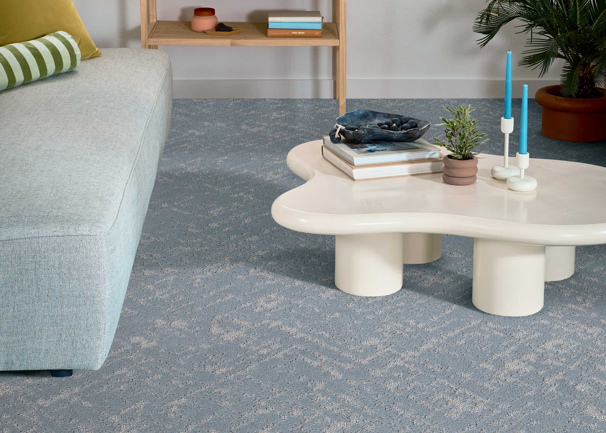 muted dusty blue medium pile carpet in living room with light gray sofa and cream kidney shaped coffee table