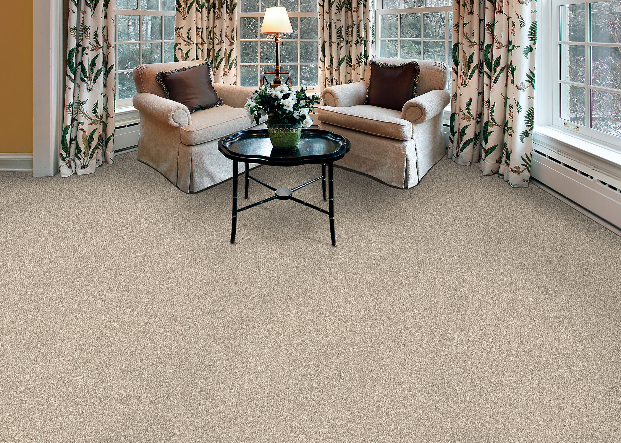 Creamy almond shag textured carpet in living room with matching taupe upholstered armchairs and small round cocktail table plus floral drapes