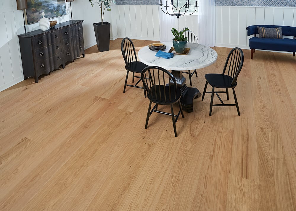 7/16 in x 10.67 in Faroe Island White Oak Engineered Hardwood Flooring in dining room with round marble dining table plus black chairs and navy settee plus shiplap on walls