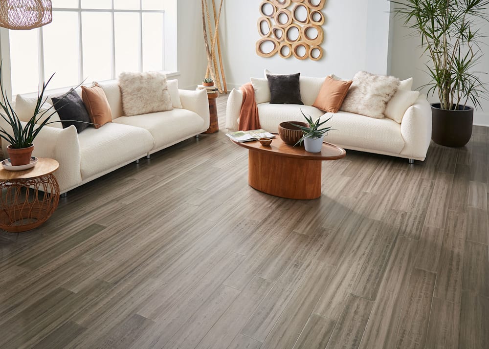 3/8 in x 5.12 in Cordova Quick Click Engineered Bamboo Flooring in living room with off white matching sofas with rust accent pillows plus large potted plant and medium wood tone coffee table