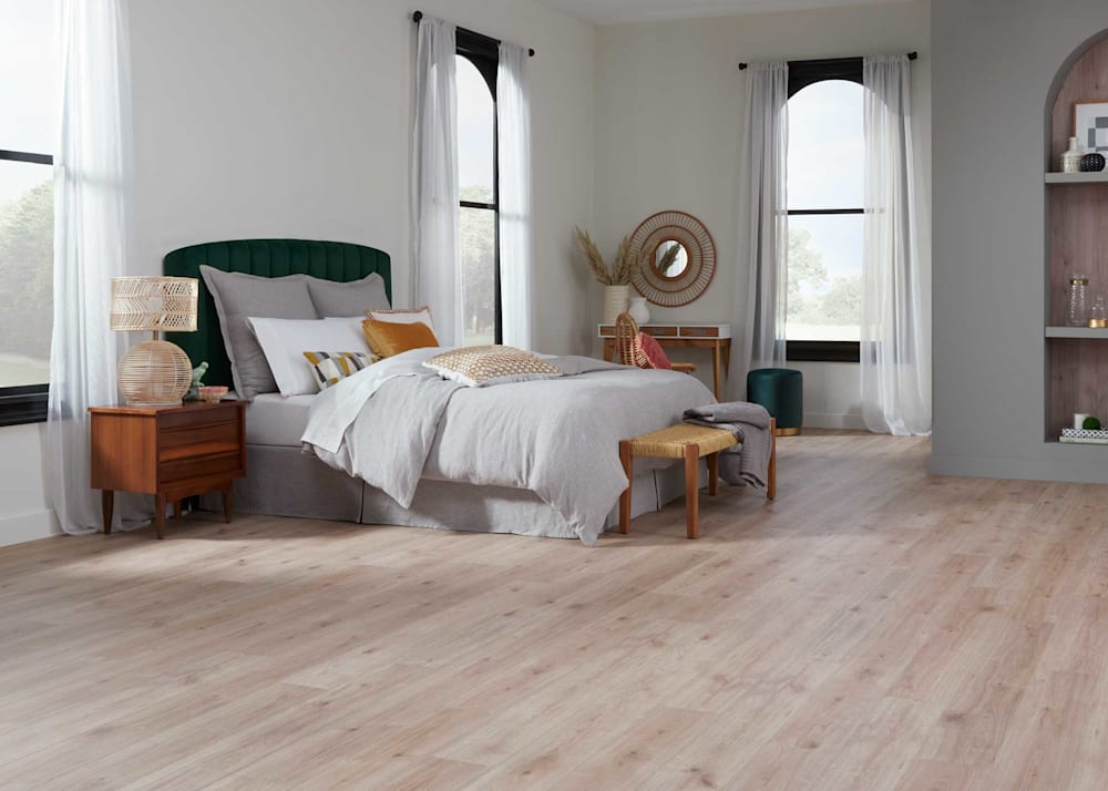 5mm with Pad Rotterdam Autumn Oak Rigid Vinyl Plank Flooring in bedroom with green headboard with light gray bedding