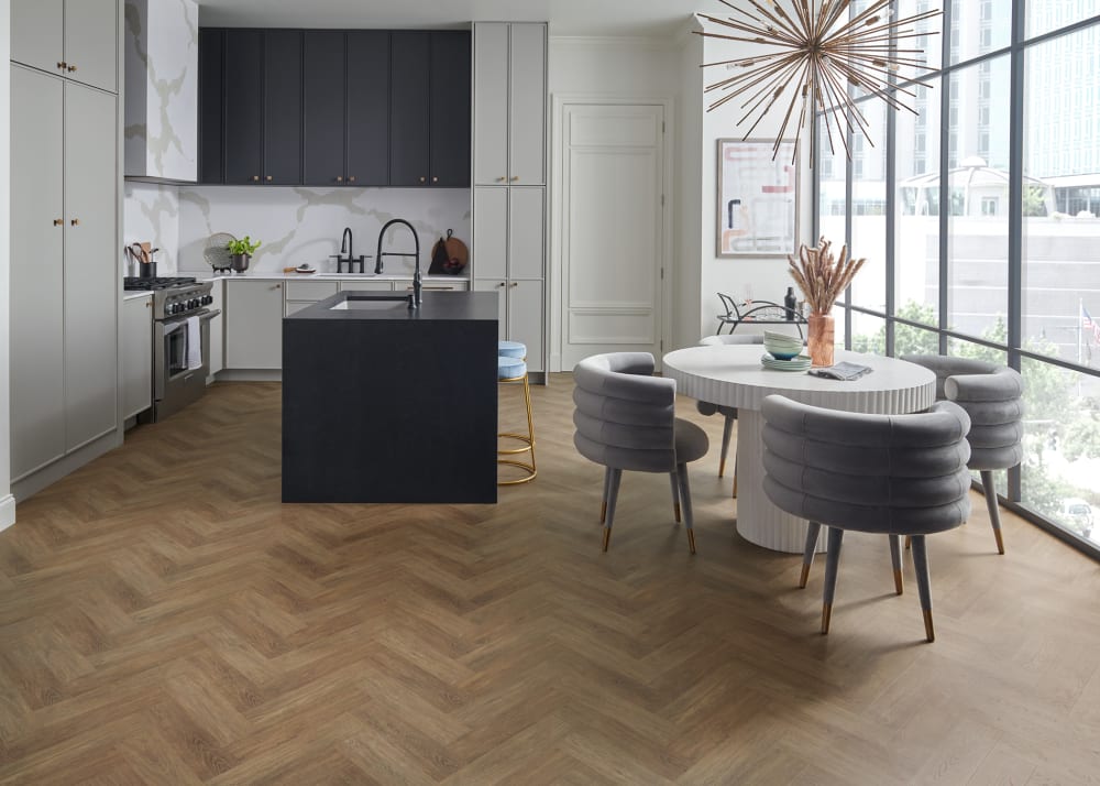 12mm+Pad Pasadena Herringbone Waterproof Laminate Flooring in contemporary kitchen with black cabinets and gold starburst chandelier