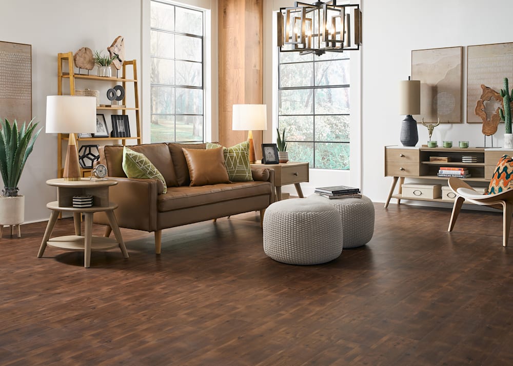 2mm Prince County Knotty Oak Luxury Vinyl Plank Flooring in living room with caramel leather sofa plus light wood tables and chairs and oatmeal colored poofs