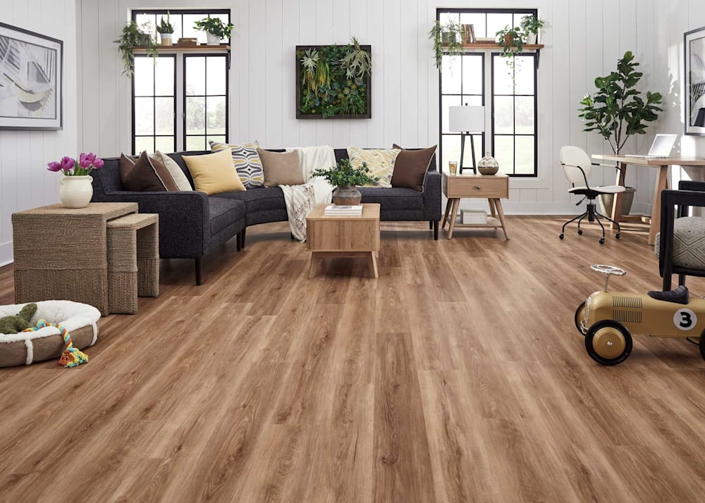 6mm with Pad Roosevelt Oak Waterproof Rigid Vinyl Plank Flooring in living room with black upholstered sectional with blonde wood tables plus shiplap walls and butcher block window shelving with plants