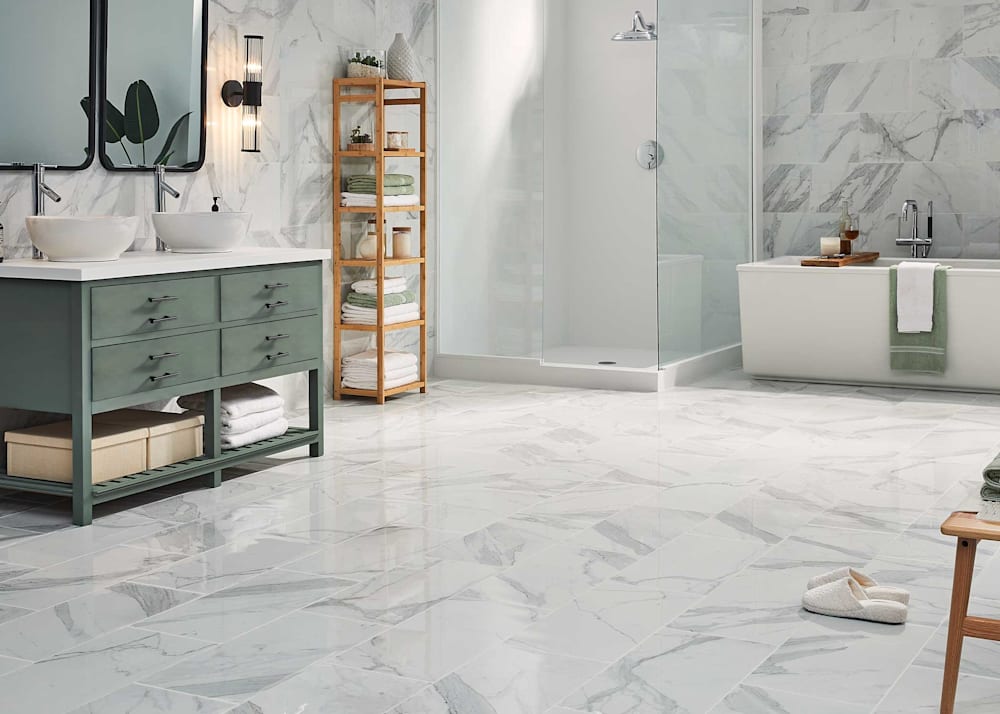 12 in x 24 in Marmo Magnifico Lucido Porcelain Tile Flooring in bathroom with floor to ceiling tile plus glass enclosed freestanding shower and freestanding tub plus green dual vanity