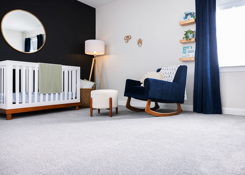San Ignacio Carpet in Cozy in nursery with dark blue upholstered rocking chair and white crib with green blanket